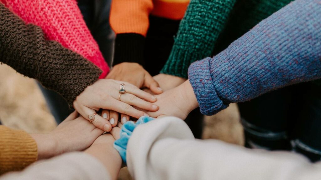 Eight women holding their hands together